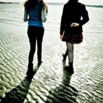 Friends Walking on Beach at Sunset