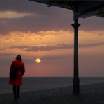 Separated man and woman watching sunset