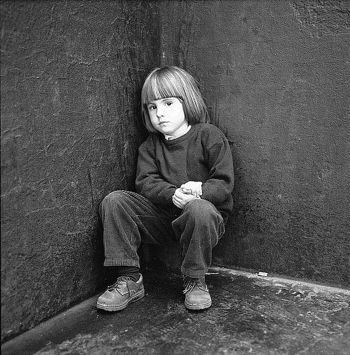 Worried girl crouching in corner