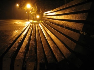 Bench shimmering in night rain